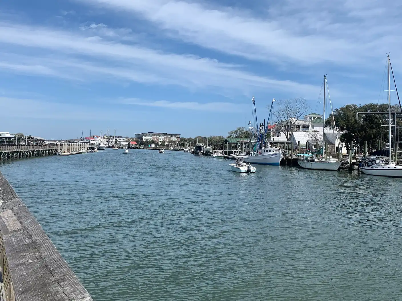 Shem Creek in Mount Pleasant, with sailboats and shrimp boats moored along the docks and waterfront buildings