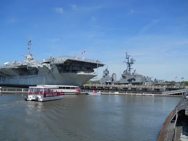 The aircraft carrier USS Yorktown and other museum ships moored at Patriots Point, with a small harbor boat in front