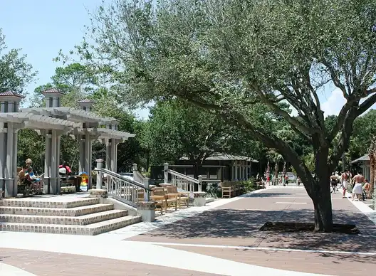 White pavilions and a large live oak along the paved plaza at Coligny Beach Park on Hilton Head Island