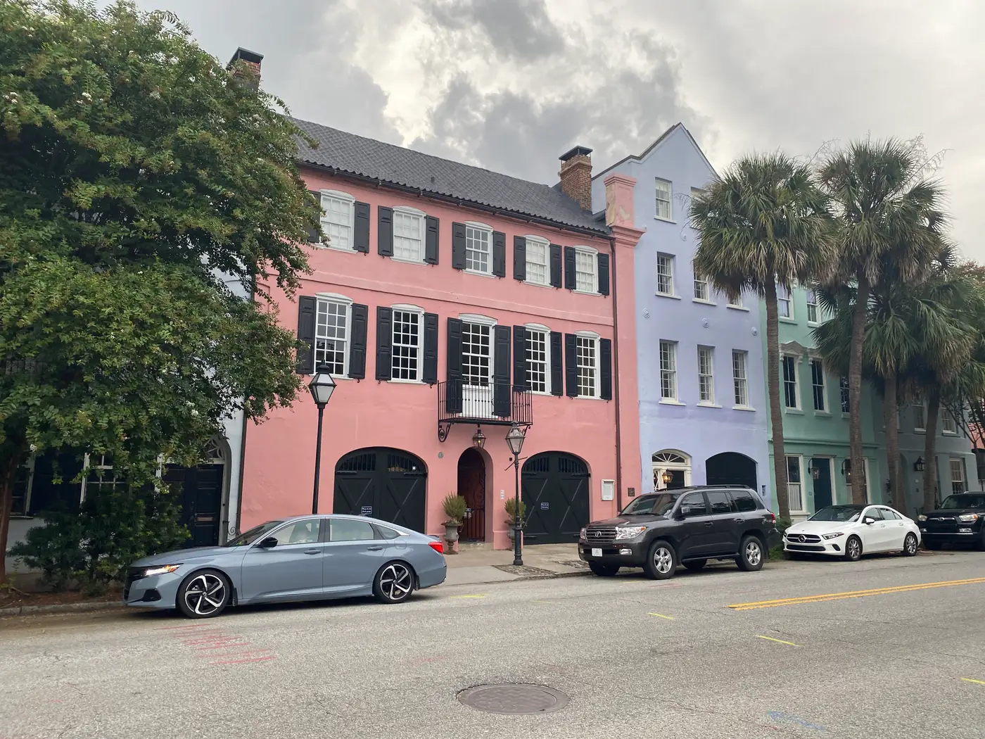 Pastel pink, lavender and green row houses with palmetto trees along East Bay Street in downtown Charleston